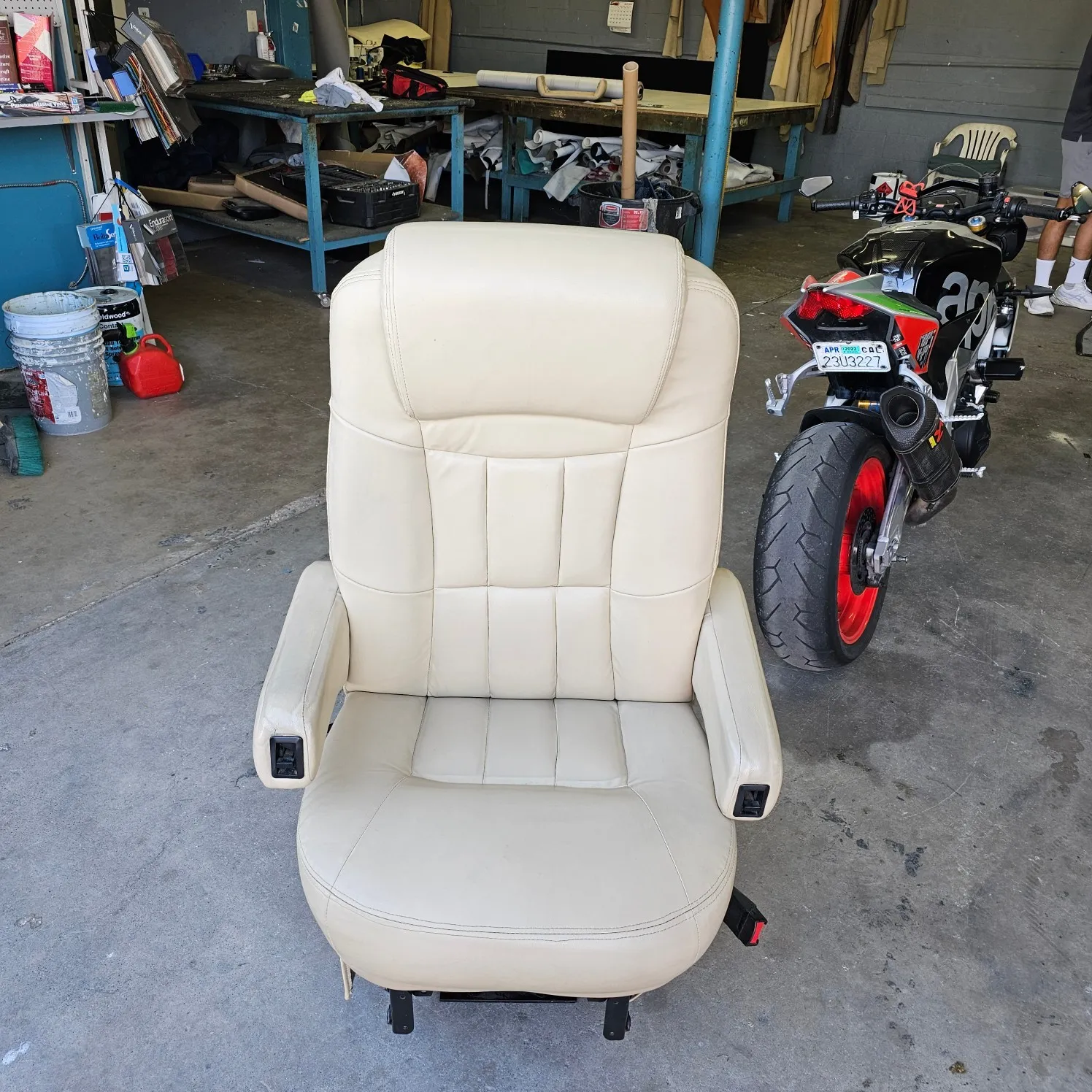 White motorcycle parked in a garage next to a white leather seat